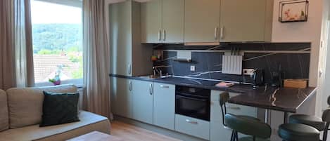 A modern kitchen with a dining area, a sofa, and a coffee table.