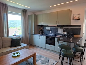 Una cucina moderna con zona pranzo, divano e tavolino.