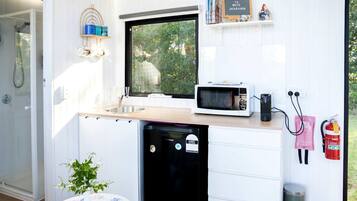 A compact kitchen with a built-in microwave, sink, and dishwasher.
