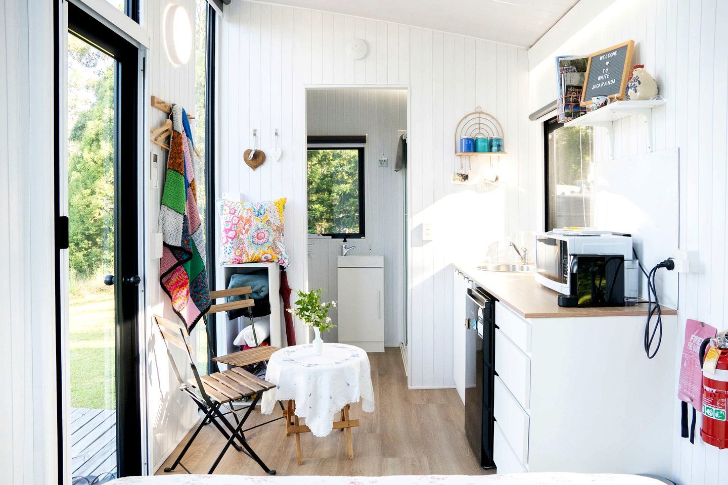 A compact kitchen with a dining area, a small table, and a view of the outdoors.