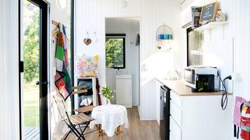 A compact kitchen with a dining area, a small table, and a view of the outdoors.