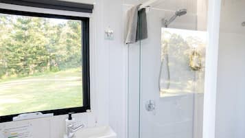 A bathroom with a window, a sink, and a shower.