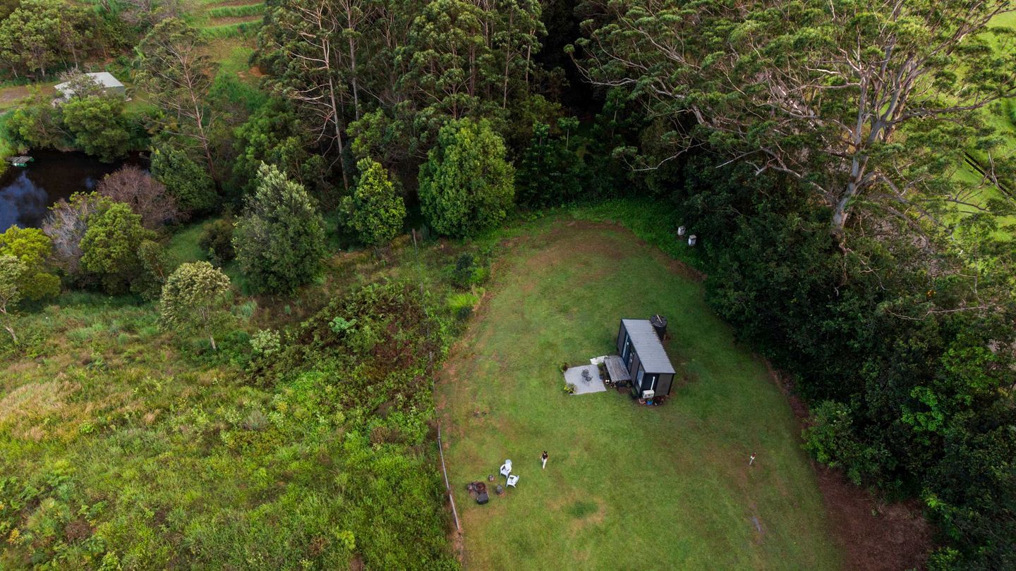 A small, secluded property with a single building surrounded by dense forest.