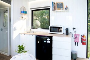 A compact kitchen with a built-in microwave, sink, and dishwasher.