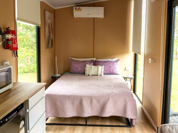 A bedroom with a bed, bedside table, and a window.