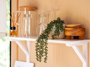 A shelf with glass bottles, a plant, and wooden containers.