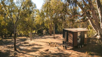 A campsite with a small wooden cabin, a picnic table, and a fire pit.