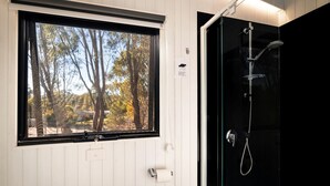 A bathroom with a window, a shower, and a door. - Luminous Tiny House Perfect for Water and Winter Sports in Victoria, Australia (Howes Creek)