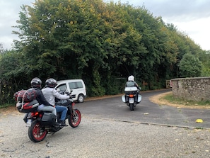 A road with two motorcyclists and a white van.