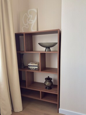 Een hoekplank met een decoratieve schaal, een kleine vaas en boeken.