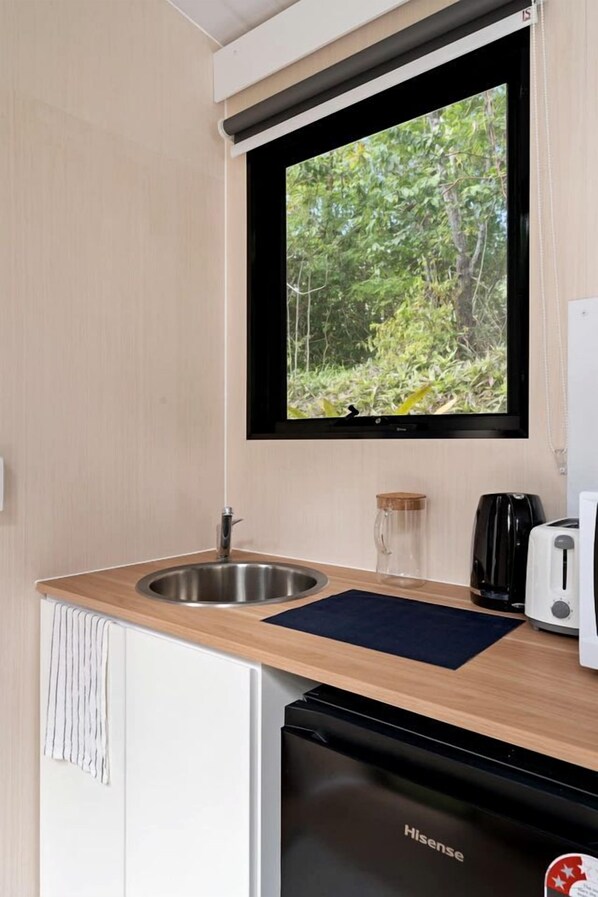 Cocina compacta con lavamanos, tostador y lavavajillas Hisense.