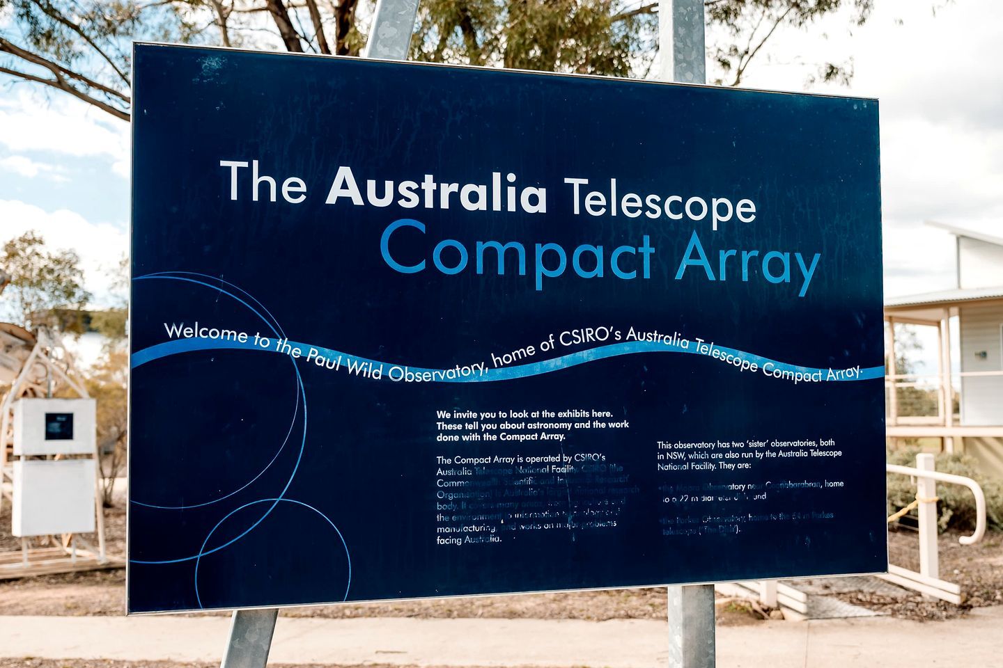 A signboard for The Australia Telescope Compact Array, welcoming visitors to the Paul Wild Observatory.