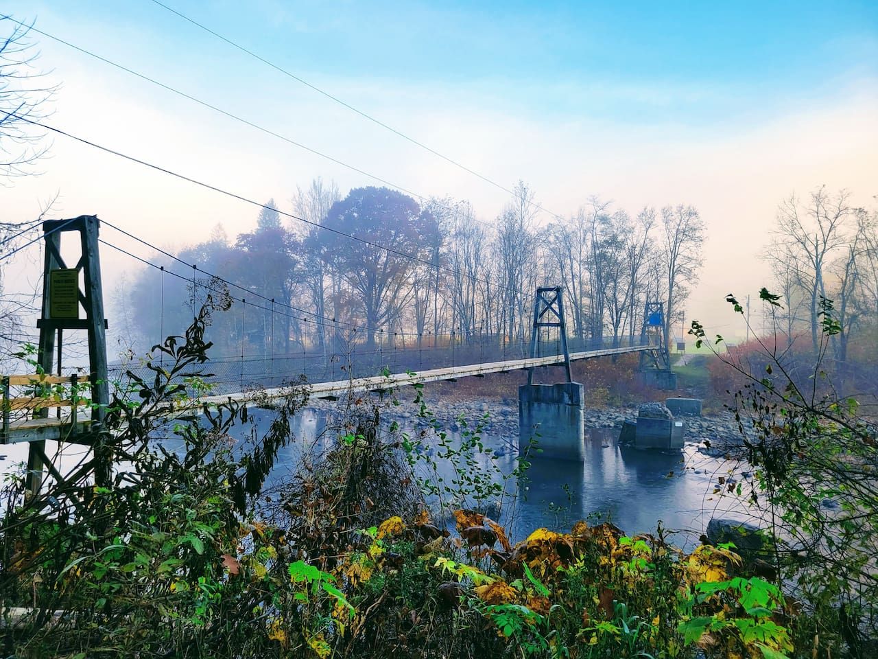 A bridge over a body of water with trees in the background.