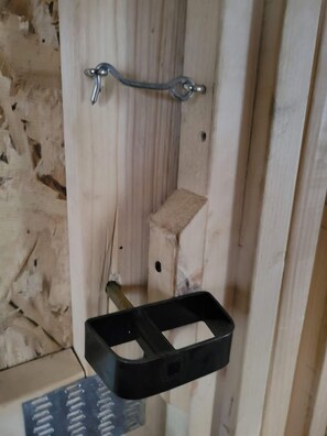 A wooden door with a metal handle and a black object hanging on it.
