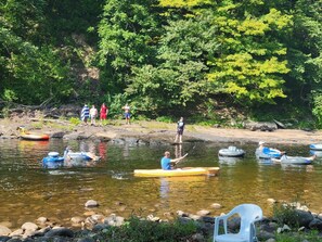 A river with people in inflatable boats and a few standing on the bank. - The Parsons - Cabin CB1 (Parsons)