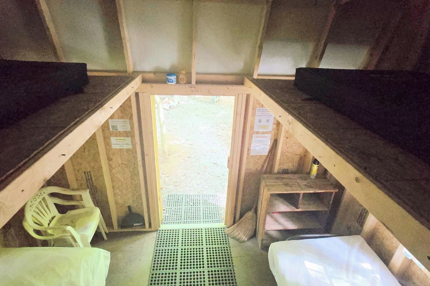 A cabin interior with bunk beds, a small table, and a chair.