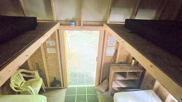 A cabin interior with bunk beds, a small table, and a chair.