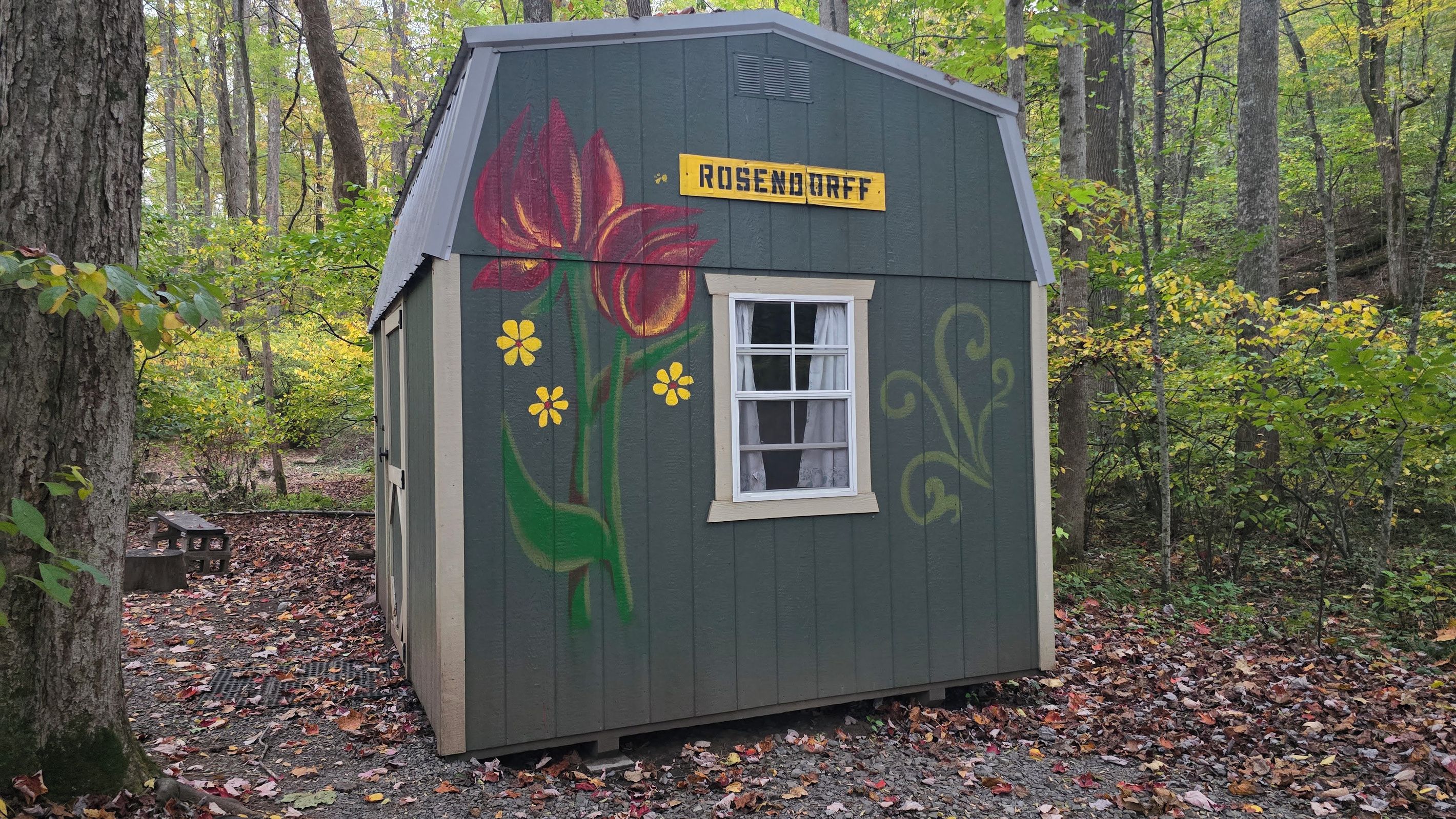 A small wooden structure with a window and a sign that reads 'ROSENDURFF' painted on the side.