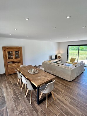 A modern living space with a dining area, a sofa set, and a wooden cabinet. - Villa 'Loan' with Private Terrace, Wi-Fi and Air Conditioning (Mollans-sur-Ouvèze)