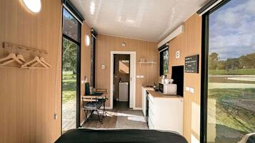 Una habitación con cama, una kitchenette pequeña y vistas al exterior.