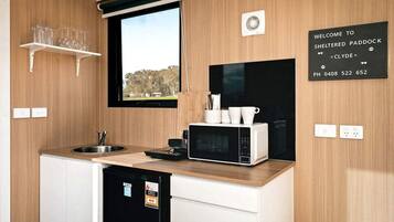 Una cocina moderna con microondas integrado, una ventana y un cartel de bienvenida.