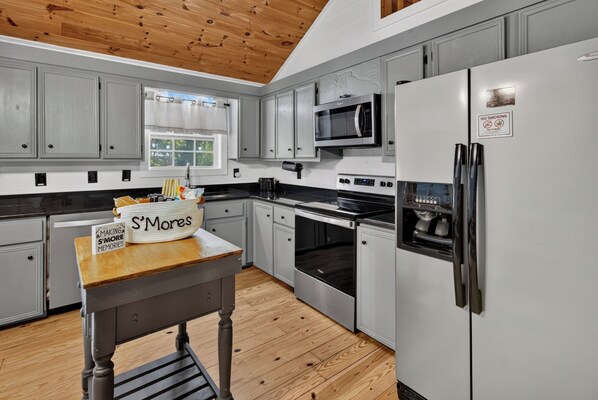 A modern kitchen with grey cabinets, a stainless steel refrigerator, a microwave, and a stove. - Cozy 2 Bed 2 Bath River Cabin Hot Tub Ellijay GA Blue Ridge Mt Pet Friendly (Ellijay)