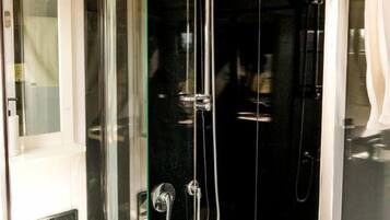 Une salle de bain moderne avec une douche à parois de verre, un lavabo blanc et un miroir.