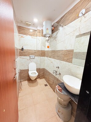A bathroom with a toilet, sink, and a water heater.