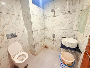 A bathroom with a toilet, a sink, and a shower. - Hotel Mahakal Sagar (Ujjain)