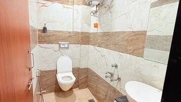 Une salle de bain équipée de toilettes, d’un lavabo et d’un chauffe-eau.