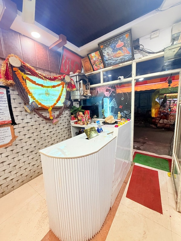 Un área de recepción con mostrador, rueca de oración y decoraciones religiosas.