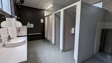 Een moderne badkamer met een wit wastafelmeubel, een spiegel en een betegelde vloer.