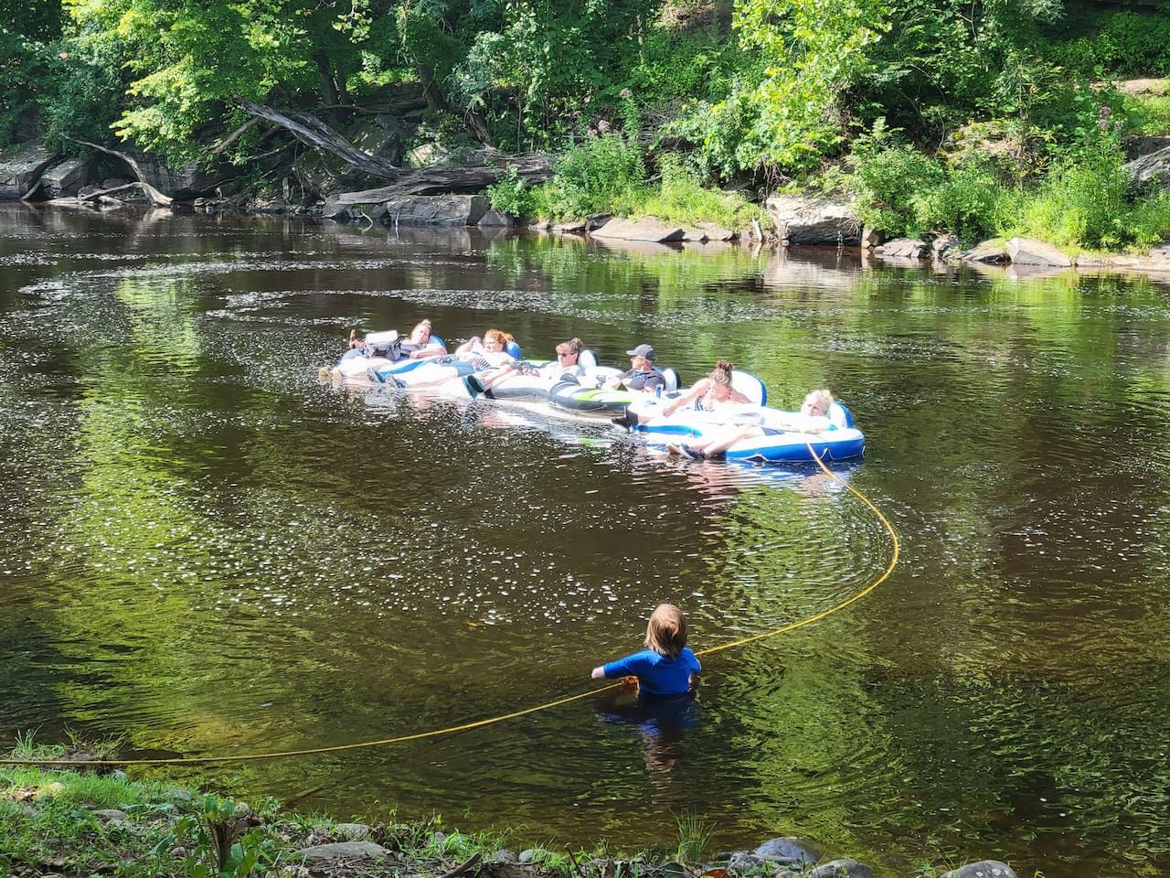 Un grupo de personas en balsas inflables en un río rodeado de vegetación.