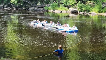 Un grupo de personas en balsas inflables en un río rodeado de vegetación.