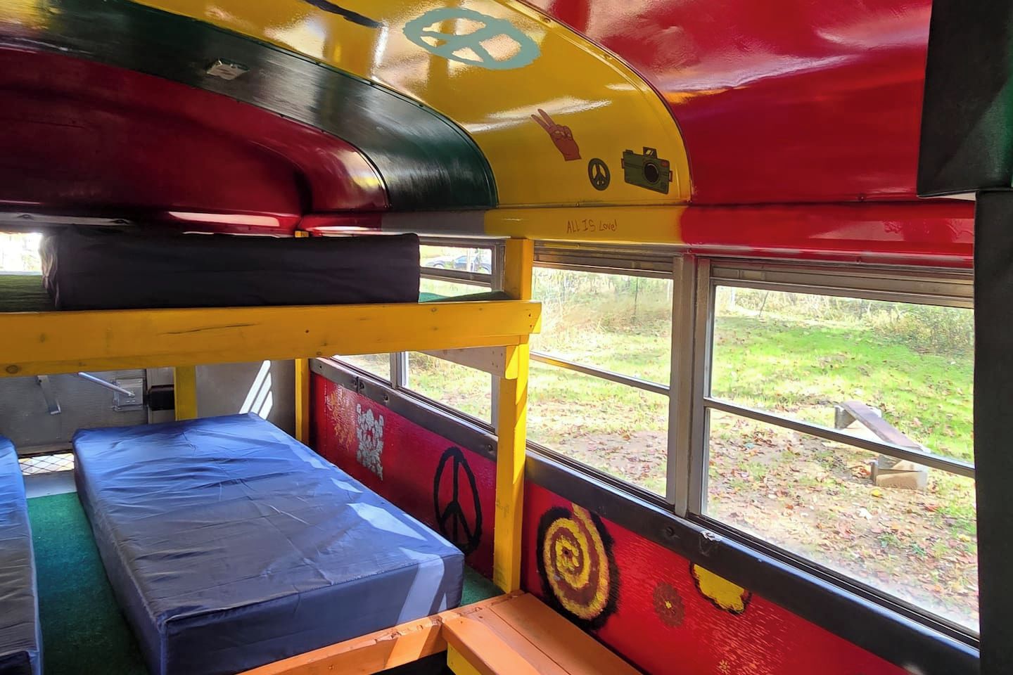 Interior de autobús con literas y una ventana.