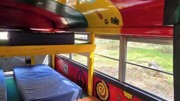 Interior de autobús con literas y una ventana.