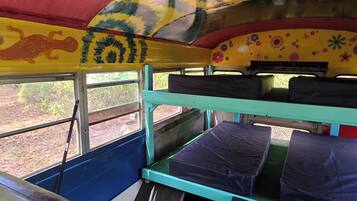 L'intérieur d'un autobus, avec des couchettes, une fenêtre et une fresque murale.