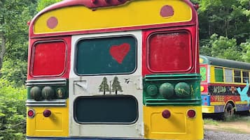 Un autobús colorido con un corazón y árboles pintados en la parte trasera.