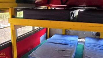 Un lit superposé avec un matelas en haut et un lit inférieur avec un oreiller.
