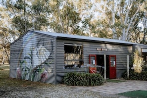 A small building with a 'REC ROOM' sign, a mural on the side, and a red door. - Cozy Tiny House Loft with Living Room Space and Game Room in Victoria, Australia (Dadswells Bridge)