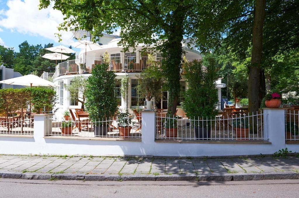 Un edificio moderno con fachada blanca, varios balcones y zonas de estar al aire libre.