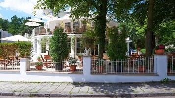 Un edificio moderno con fachada blanca, varios balcones y zonas de estar al aire libre.