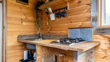 Una cucina compatta con piano di lavoro in legno, lavello e fornello a gas.