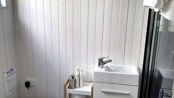 Ein Badezimmer mit Toilette, Waschbecken, Dusche und Handtuchhalter.