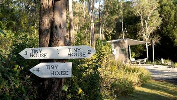 A directional signpost with arrows pointing to 'Tiny House 3', 'Tiny House 2', and 'Tiny House 4'.
