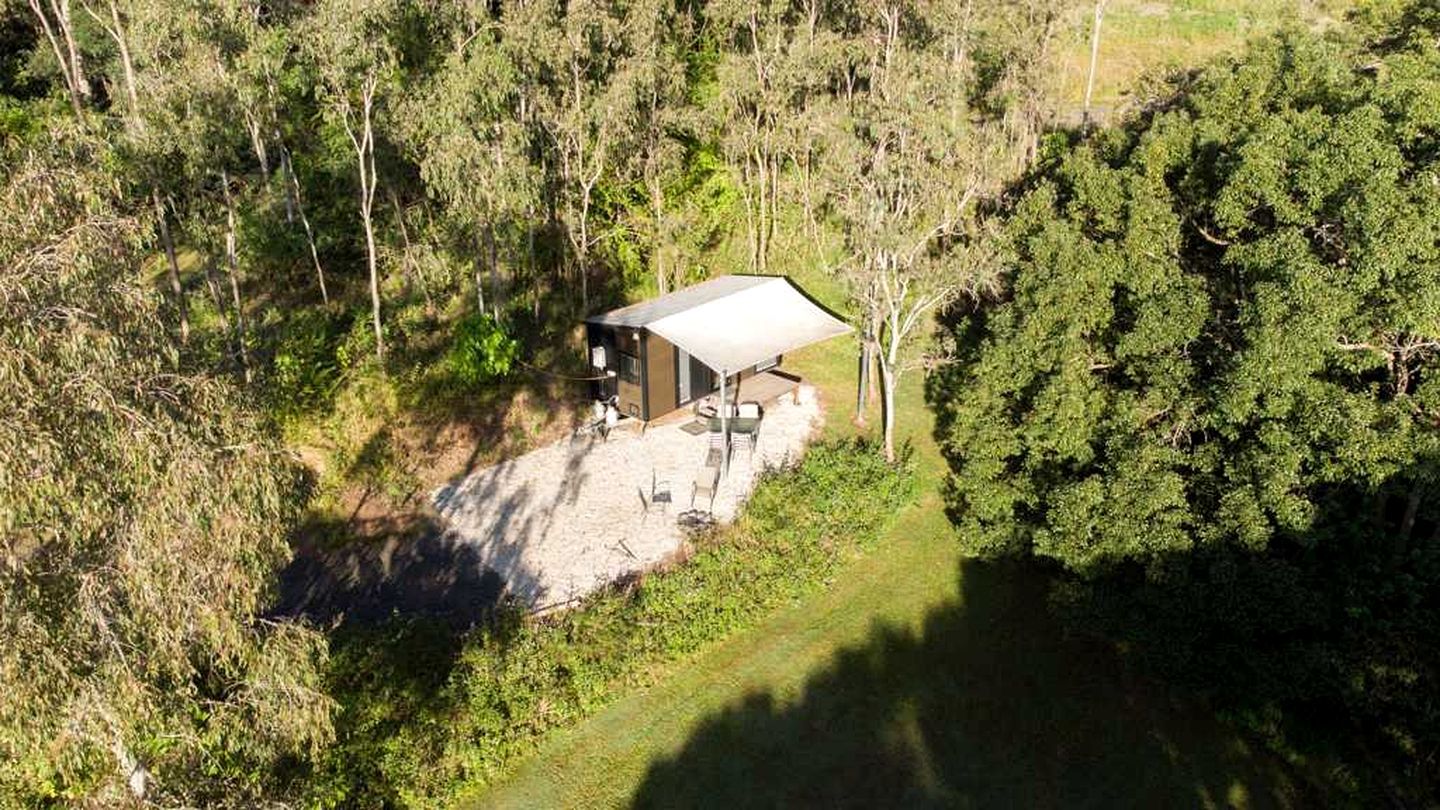 A single-story building with a flat roof, surrounded by dense forest.