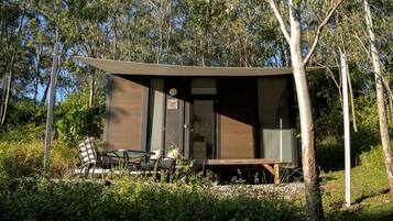 A modern, single-story building with a flat roof, surrounded by trees.