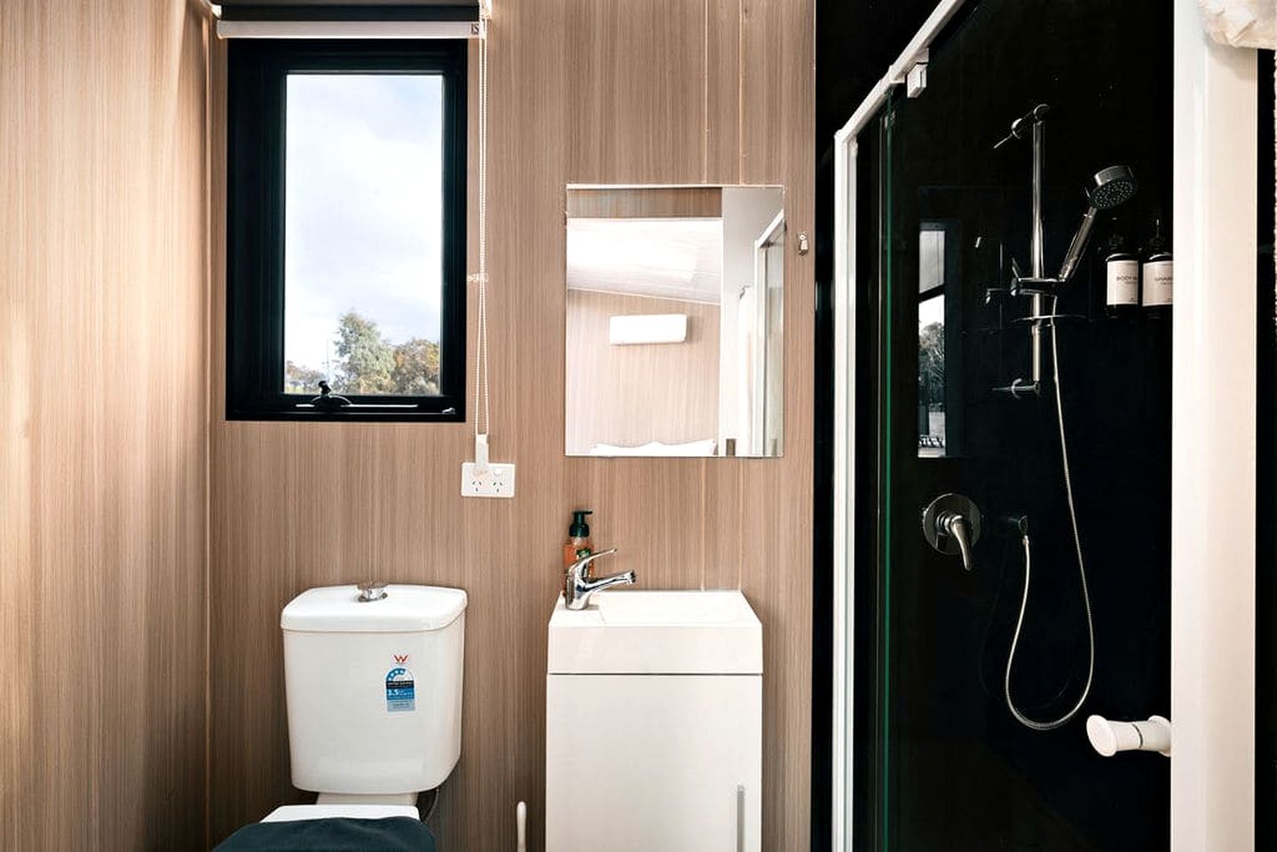 A modern bathroom with a toilet, sink, and shower.