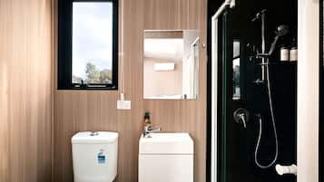 A modern bathroom with a toilet, sink, and shower.