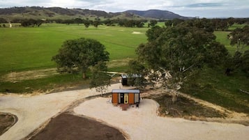 Un edificio pequeño de un solo piso con un camino de tierra y un sendero de grava que lo conducen.